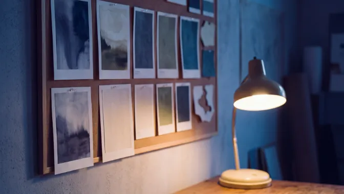 Printed proofs pinned to a corkboard wall